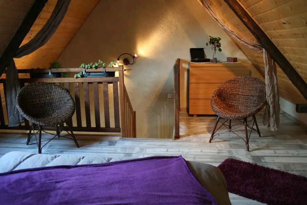 Chambre en mezzanine, avec deux fauteuils à disposition