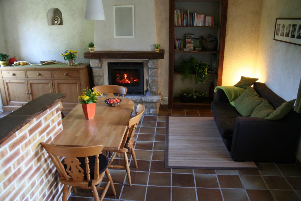 Espace de vie avec table à manger, bibliothèque et canapé convertible à disposition
